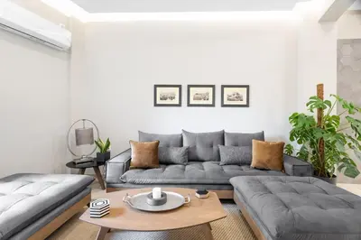a living room with a couch and a table at Deluxe 3-BDRM Urban-industrial Apt at Acropolis in Athens