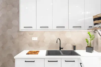 a kitchen with white cabinets and a sink at Deluxe 3-BDRM Urban-industrial Apt at Acropolis in Athens