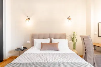 a bedroom with a large bed with white pillows at Deluxe 3-BDRM Urban-industrial Apt at Acropolis in Athens