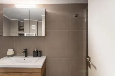 a bathroom with a sink and a shower at Deluxe 3-BDRM Urban-industrial Apt at Acropolis in Athens