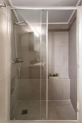 a shower with a glass door in a bathroom at Deluxe 3-BDRM Urban-industrial Apt at Acropolis in Athens