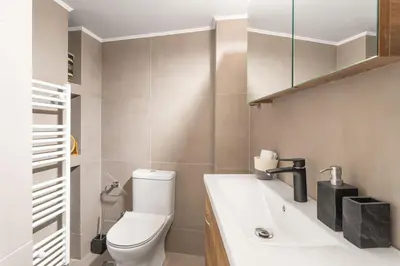 a bathroom with a white toilet and a sink at Deluxe 3-BDRM Urban-industrial Apt at Acropolis in Athens
