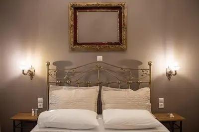 a bed with two pillows and a mirror on the wall at Beautiful City Suites in Athens