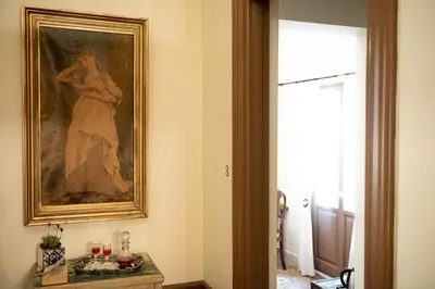 a painting of a woman on a wall next to a table at Beautiful City Suites in Athens