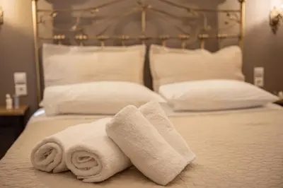 a bed with two towels on top of it at Beautiful City Suites in Athens