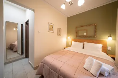 a bedroom with a large bed and a mirror at Beautiful City Suites in Athens