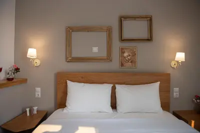 a bedroom with a bed with white pillows and two mirrors at Beautiful City Suites in Athens