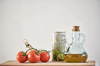 a shelf with tomatoes and a bottle of olive oil and a jar of vinegar at Contemporary & Comfy Apt next to Acropolis Museum in Athens