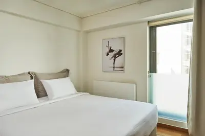 a bedroom with a white bed and a window at Contemporary & Comfy Apt next to Acropolis Museum in Athens
