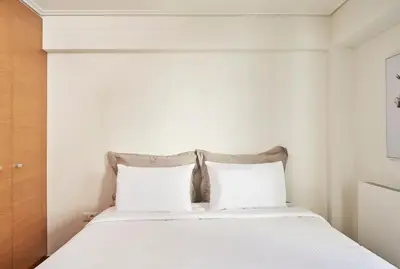 a bedroom with a white bed with two pillows at Contemporary & Comfy Apt next to Acropolis Museum in Athens