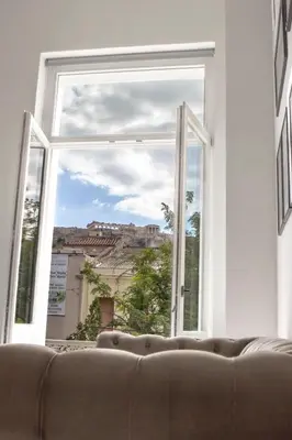 a couch sitting in front of a large window at Azelia Suites - Acropolis View in Athens