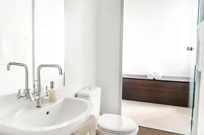 a white bathroom with a sink and a toilet at Azelia Suites - Acropolis View in Athens