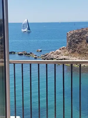 a sailboat in the water from a balcony at BEDWAVE Seaside Mansion in Piraeus