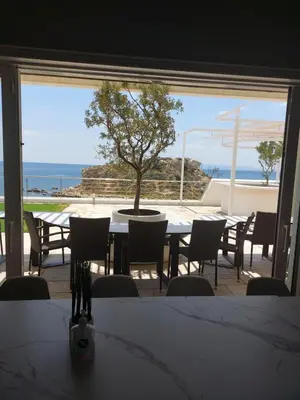 a dining room with a table and a tree on a patio at BEDWAVE Seaside Mansion in Piraeus