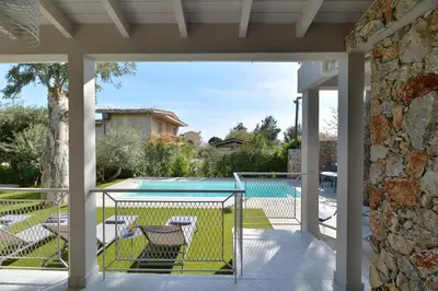 a patio with a view of a swimming pool at Lagonisi luxurious residence Ruby's Pool Villa in Lagonissi
