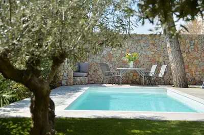 a swimming pool in a yard with a table and chairs at Lagonisi luxurious residence Ruby's Pool Villa in Lagonissi