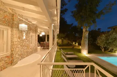 a house with a porch and a swimming pool at Lagonisi luxurious residence Ruby's Pool Villa in Lagonissi