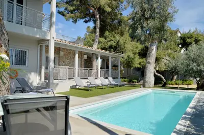 a swimming pool with chairs and a house at Lagonisi luxurious residence Ruby's Pool Villa in Lagonissi