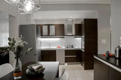 a kitchen with a table and a refrigerator at Lagonisi luxurious residence Ruby's Pool Villa in Lagonissi