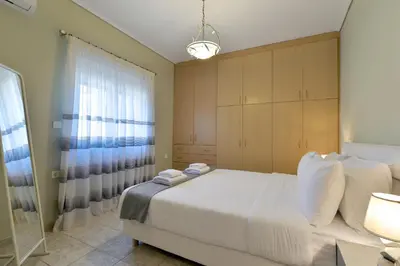 a bedroom with a large white bed and a window at Lagonisi luxurious residence Ruby's Pool Villa in Lagonissi