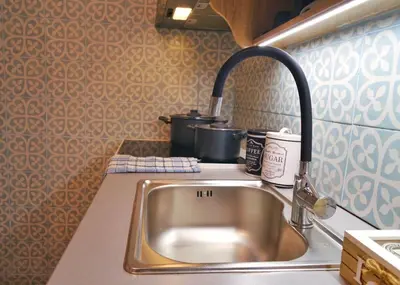 a kitchen counter with a sink and two pots at Royal Blue Grand Suite No 3 in Piraeus