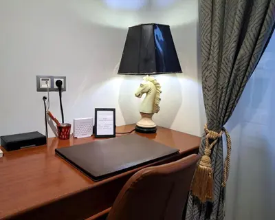 a desk with a laptop and a lamp on it at Royal Blue Grand Suite No 3 in Piraeus