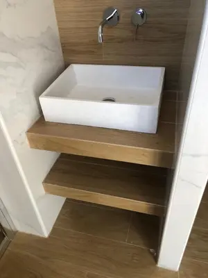 a bathroom with a white sink on a wooden shelf at Metropolitan Complex Suite Faliro in Piraeus