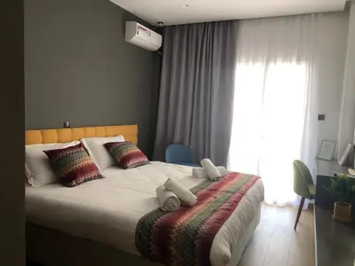 a bedroom with a bed with pillows and a window at Metropolitan Complex Suite Faliro in Piraeus