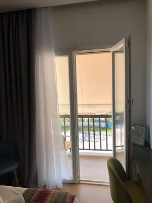 a bedroom with a sliding glass door to a balcony at Metropolitan Complex Suite Faliro in Piraeus