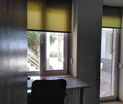 a dining room with a table and two windows at Piraeus Suite~Ermioni Villas in Piraeus