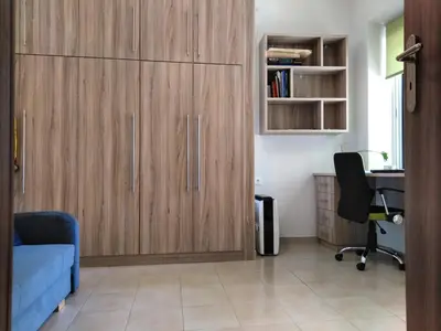 a living room with wooden cabinets and a desk at Piraeus Suite~Ermioni Villas in Piraeus