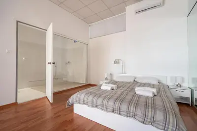 a white bedroom with a bed and a walk in shower at Cinema Zeus Studios - by Avelink in Spáta