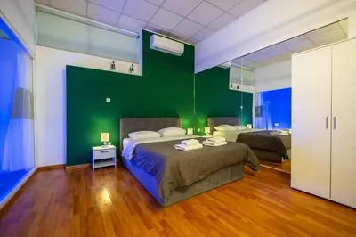 a bedroom with two beds and a green wall at Cinema Zeus Studios - by Avelink in Spáta