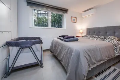 a bedroom with a bed with a chair and a window at Glyfadas Luxury Design Apartments in Athens