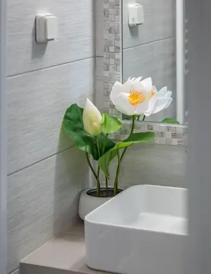 a vase with a white flower in a bathroom at Glyfadas Luxury Design Apartments in Athens
