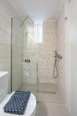 a bathroom with a shower with a toilet and a sink at Glyfadas Luxury Design Apartments in Athens
