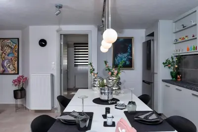 a dining room with a white table and chairs at Glyfadas Luxury Design Apartments in Athens