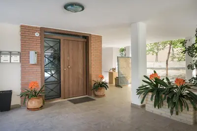 a lobby with a wooden door and two potted plants at Glyfadas Luxury Design Apartments in Athens