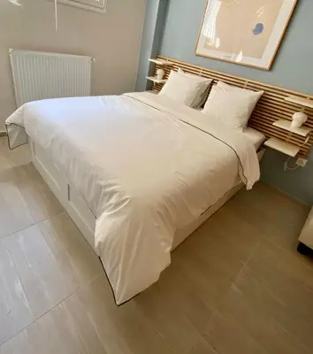a large bed with white sheets and pillows at For a genuine Athenian homestay! in Athens