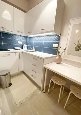 a kitchen with white cabinets and a table and chairs at For a genuine Athenian homestay! in Athens