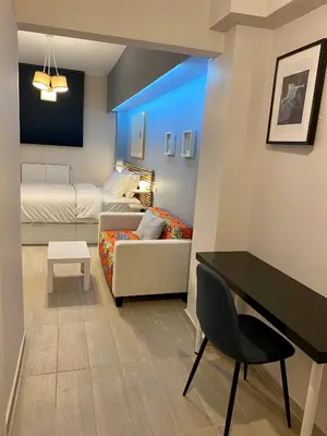a living room with a white couch and a table at For a genuine Athenian homestay! in Athens