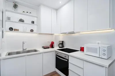 a white kitchen with a sink and a microwave at Melodies of Athens apt in Ilisia neighbourhood in Athens