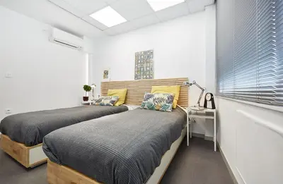 two beds in a room with a desk and a window at Chloe Boutique Apartments Apollo in Athens