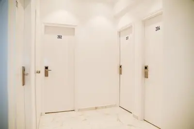a row of white doors in a room at HOTEL_TIER in Athens