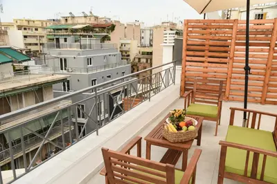 a balcony with chairs and a basket of fruit at HOTEL_TIER in Athens