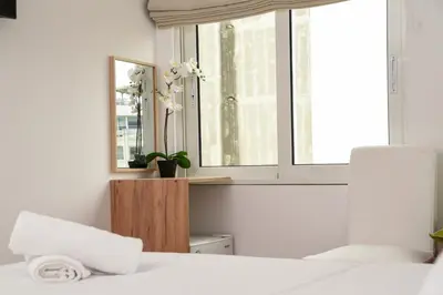 a bedroom with a window and a white bed at HOTEL_TIER in Athens