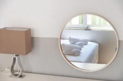 a mirror in a room with a bed and towels at HOTEL_TIER in Athens