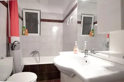 a bathroom with a white sink and a toilet at SK-George Apartments by the Sea and Airport in Porto Rafti