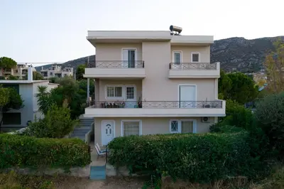 a large white house with a balcony at SK-George Apartments by the Sea and Airport in Porto Rafti