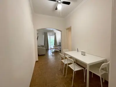 a dining room with a white table and chairs at Faliro Apartments Next To The Beach in Athens